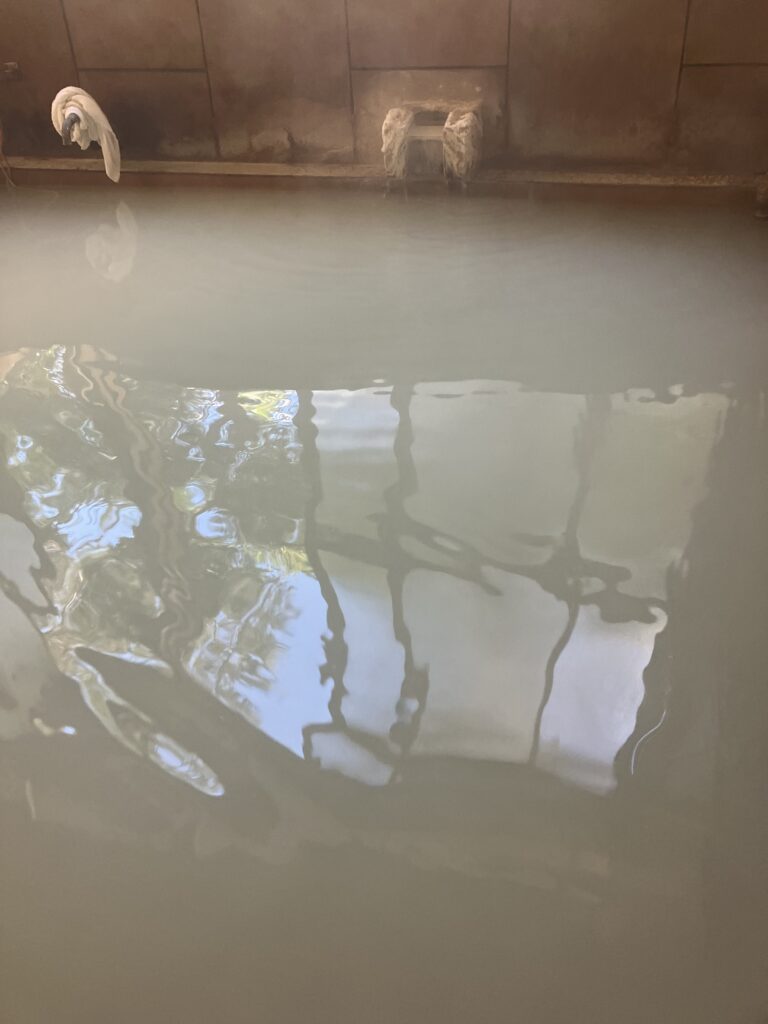 Murky green-grey water in a hot spring bath